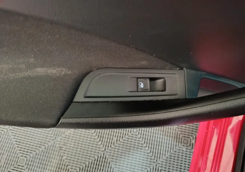 Bouton de verrouillage des portes sur la portière côté conducteur d’un SKODA KAMIQ rouge, vue intérieure rapprochée.