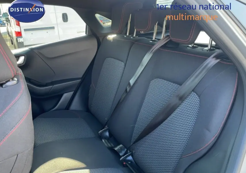 Vue intérieure arrière du Ford Puma 2023, sièges tissu noir avec surpiqûres rouges et ceintures de sécurité noires.