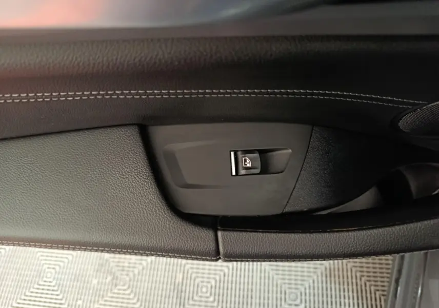 Détail de la commande de verrouillage de porte sur la garniture intérieure côté gauche d’un BMW X3 gris foncé xDrive30e 2020.