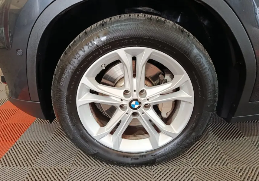 Gros plan sur la roue avant droite gris foncé du BMW X3 xDrive30e avec jante alliage à 5 doubles branches.