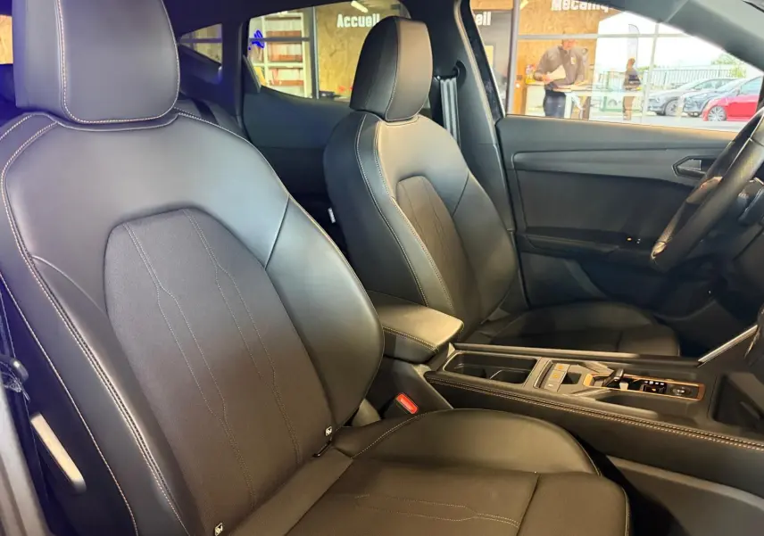 Vue intérieure côté gauche montrant les sièges sport cuir/tissu noirs et la console centrale du CUPRA Formentor 2025.