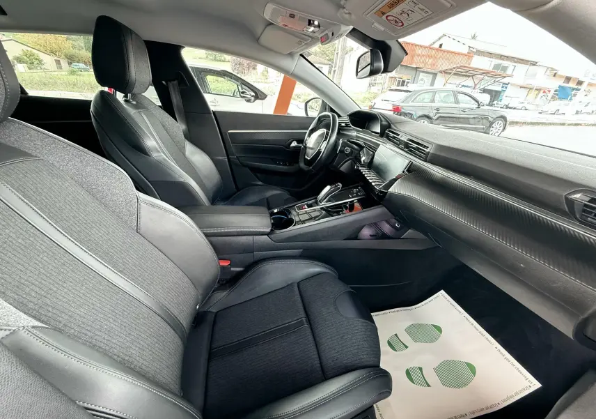 Intérieur noir de la Peugeot 308 SW 2018, vue côté conducteur montrant sièges et tableau de bord moderne.