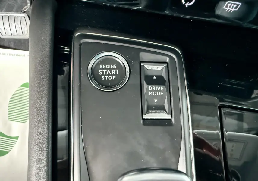 Gros plan sur le bouton start/stop et la commande drive mode dans l'habitacle noir de la Peugeot 308 SW 2018.