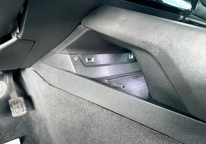 Prise USB et compartiment de rangement côté gauche sous le tableau de bord d'une Peugeot 308 SW noir métal.