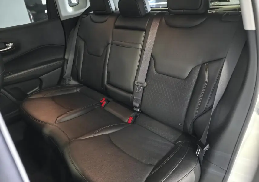 Vue intérieure sur la banquette arrière en simili cuir noir du Jeep Compass 2020 avec ceintures et appuie-têtes.