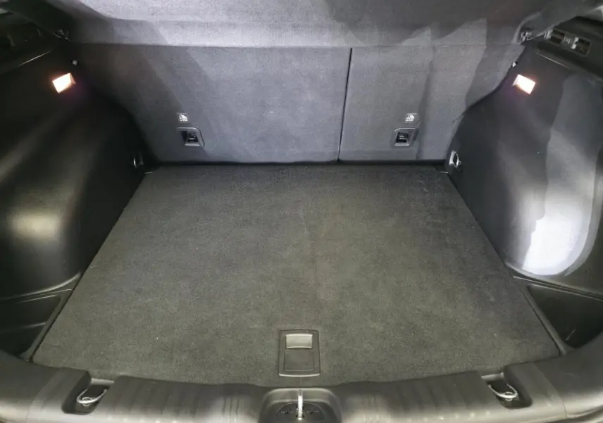 Coffre spacieux du Jeep Compass blanc 2020, vue intérieure arrière avec tapis de sol noir et éclairage intégré.