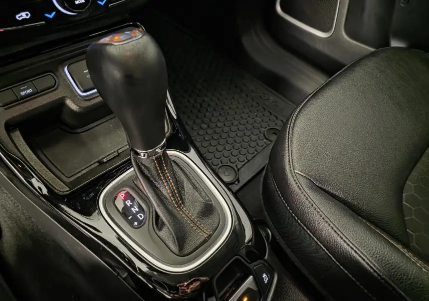 Le levier de vitesse automatique noir du Jeep Compass 2020, avec coutures orange et siège simili cuir adjacent.