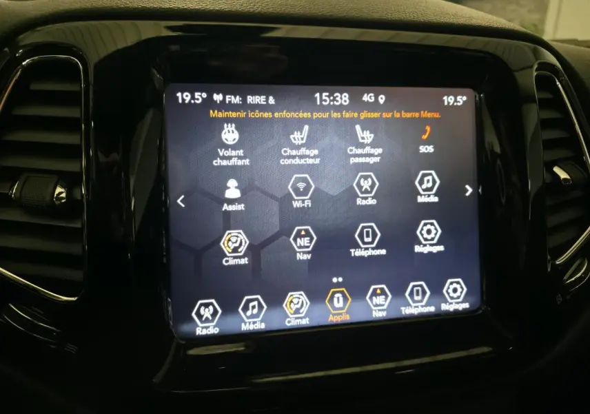 Écran tactile central du Jeep Compass 2020 affichant les commandes de climatisation et multimédia, entouré de finition noire brillante.