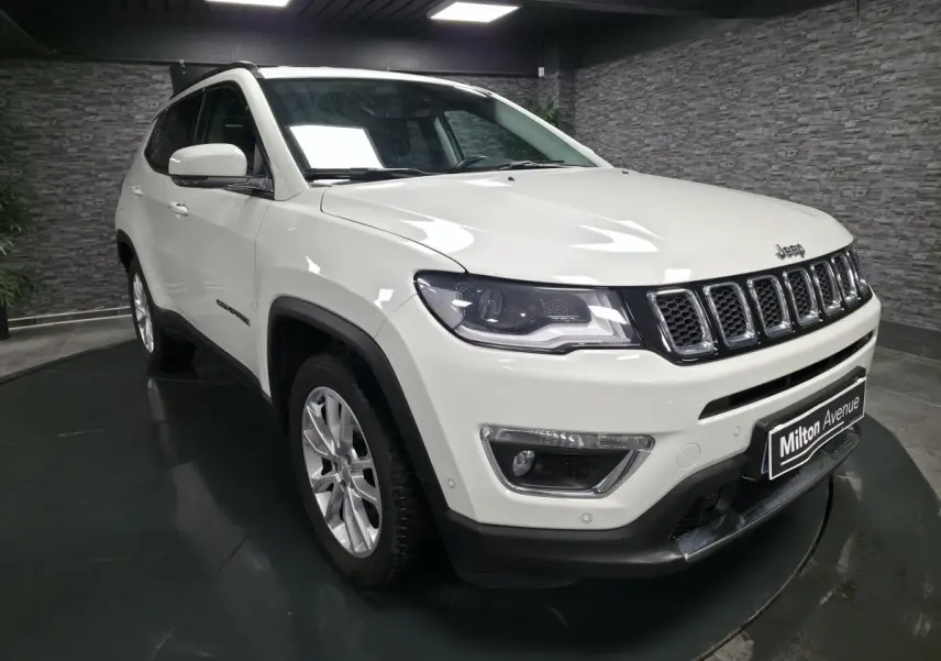 Jeep Compass blanc en 3/4 avant droit, avec jantes alliage 18 pouces et calandre distinctive à sept fentes.