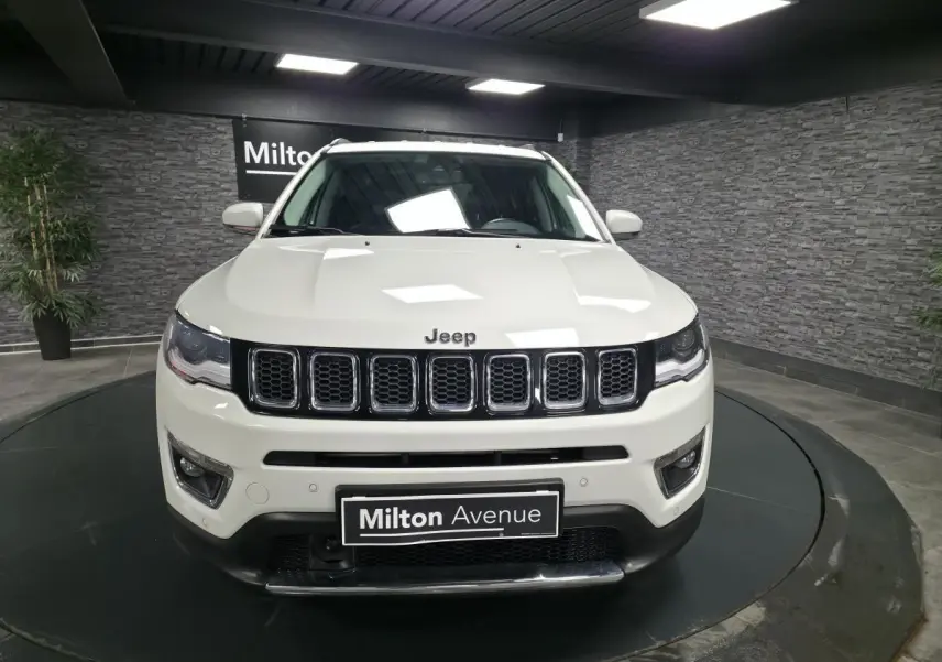 Vue frontale d'un Jeep Compass blanc Alpine White avec calandre à sept fentes et plaque Milton Avenue.