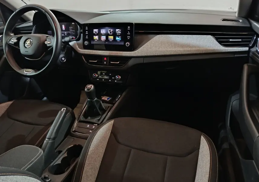 Vue intérieure avant du Skoda Kamiq 2024 avec volant cuir multifonctions, écran tactile central et boîte manuelle.
