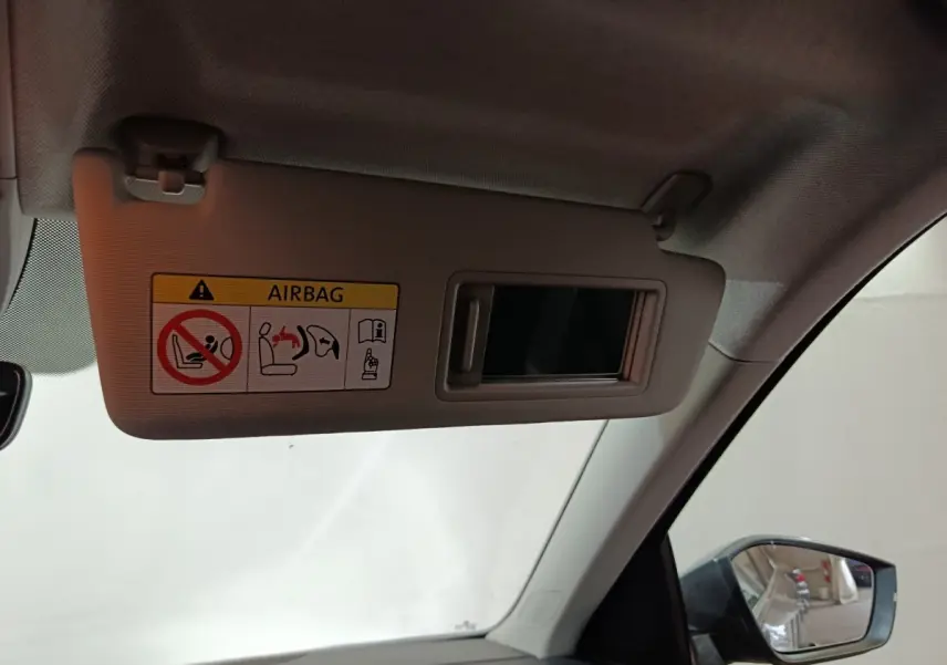 Vue intérieure du pare-soleil côté conducteur avec miroir et avertissement airbag dans un Skoda Kamiq gris clair 2024.