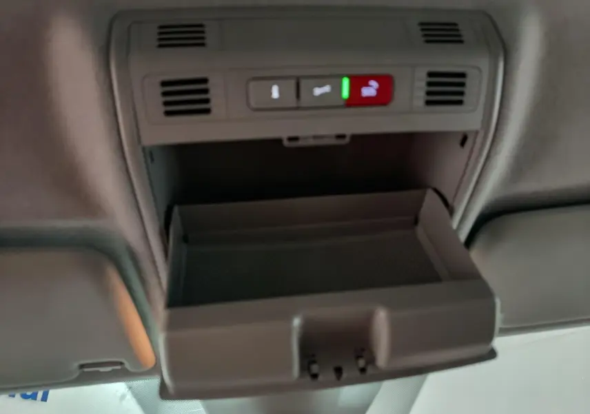 Vue intérieure du plafond avec rangement lunettes ouvert et commandes d'éclairage dans un Skoda Kamiq gris clair 2024.