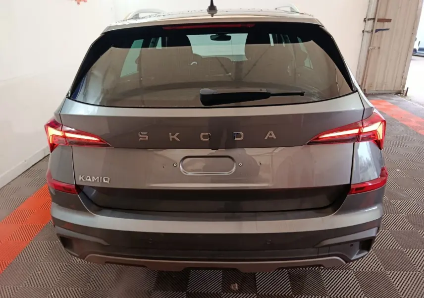Vue arrière d'un Skoda Kamiq gris clair avec feux LED allumés et logo SKODA bien visible.