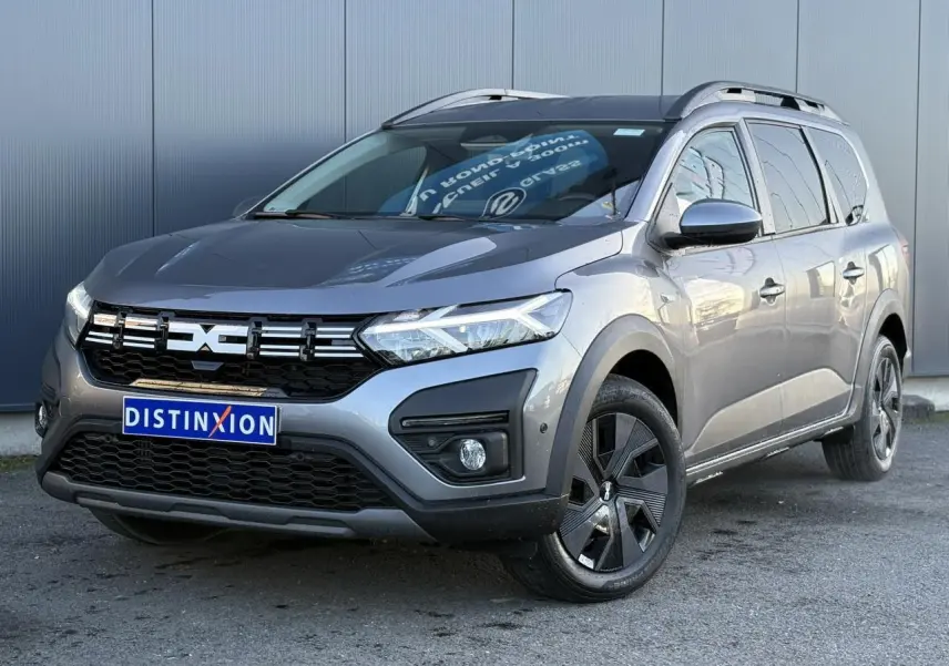 Dacia Jogger Gris Schiste en 3/4 avant droit, avec calandre noire et jantes noires distinctives.