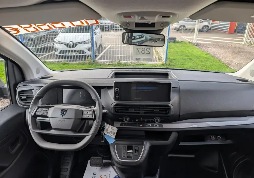 Vue intérieure avant du Peugeot Expert Fourgon noir 2025, tableau de bord moderne avec écran tactile central et volant multifonction.