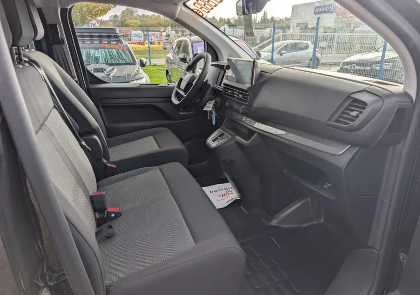 Intérieur avant du Peugeot Expert Fourgon noir 2025, vue côté conducteur montrant sièges tissu bi-ton et tableau de bord moderne.