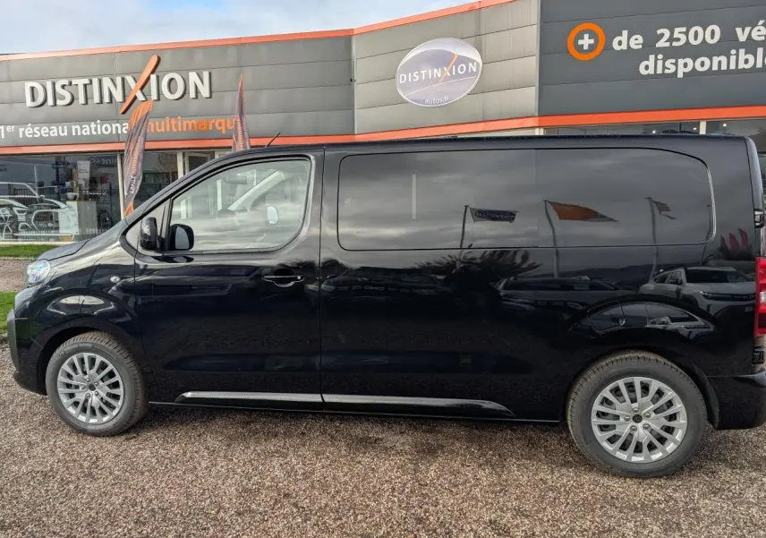 Profil côté gauche du Peugeot Expert Fourgon noir 2025 avec jantes tôle argentées et vitres latérales surteintées.