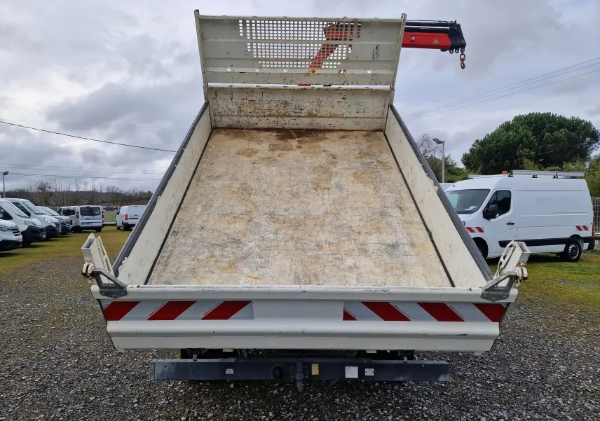 Vue arrière en contre-plongée de la benne blanche relevée d’un Iveco Daily Châssis Cabine avec grue Palfinger rouge.