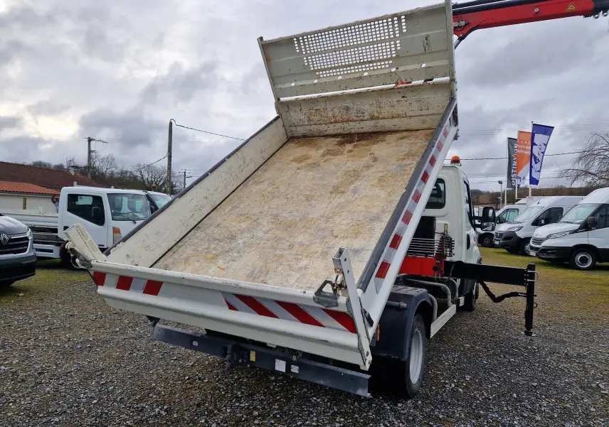 IVECO Daily Chassis Cabine blanc vu 3/4 arrière avec benne relevée et grue Palfinger déployée sur stabilisateur.