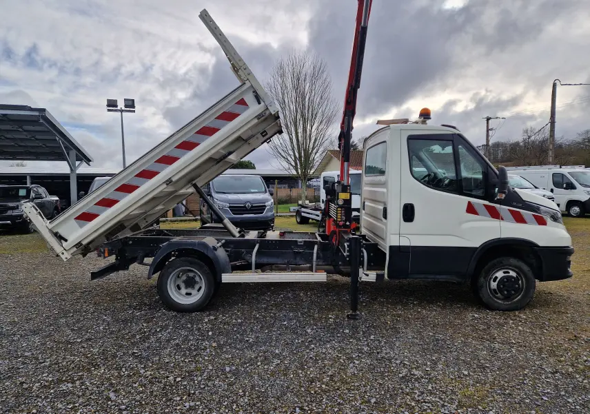 Vue de profil droit d’un Iveco Daily blanc 35C14 avec benne relevée et grue Palfinger rouge en position levée.