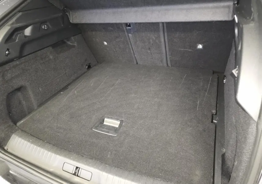 Coffre ouvert du Peugeot 3008 gris, montrant le plancher plat et les dossiers arrière rabattus.