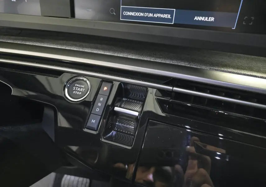 Détail de la console centrale noire laquée du Peugeot 3008 Hybrid 2025 avec bouton start/stop et sélecteur de boîte auto.