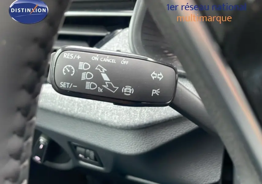 Gros plan sur la commande de régulateur de vitesse à gauche du volant d'un Skoda Kamiq gris graphite 2025.