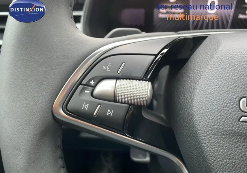 Gros plan sur les commandes gauche du volant en cuir gris du Skoda Kamiq 2025 finition Selection, avec molette et boutons noirs.