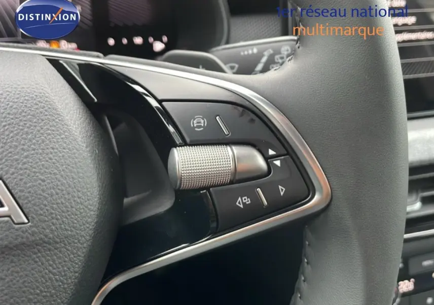 Gros plan sur les commandes du volant en cuir noir du Skoda Kamiq gris graphite, mettant en valeur les boutons multifonctions.