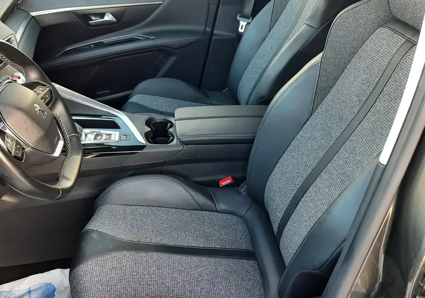 Vue intérieure côté conducteur du Peugeot 3008 2019, sièges tissu et cuir noir avec console centrale moderne.