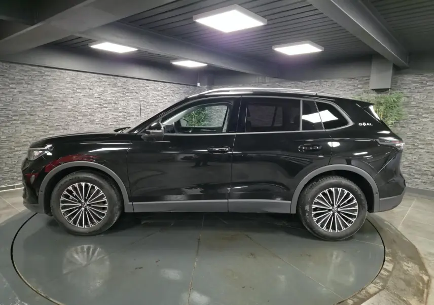 Vue de profil côté gauche du Volkswagen Tiguan noir 2025 avec jantes alliage 18 pouces et toit ouvrant.