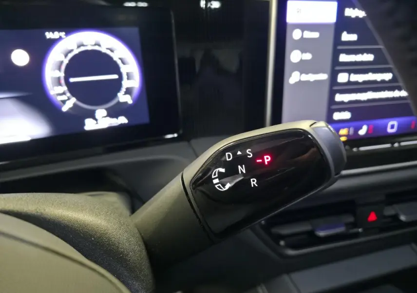 Le levier de vitesses automatique noir du Volkswagen Tiguan 2025, avec tableau de bord numérique en arrière-plan.