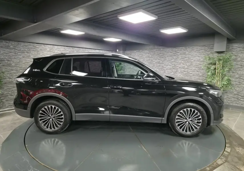 Volkswagen Tiguan noir en vue profil droit, avec jantes alliage 18 pouces et toit ouvrant panoramique.