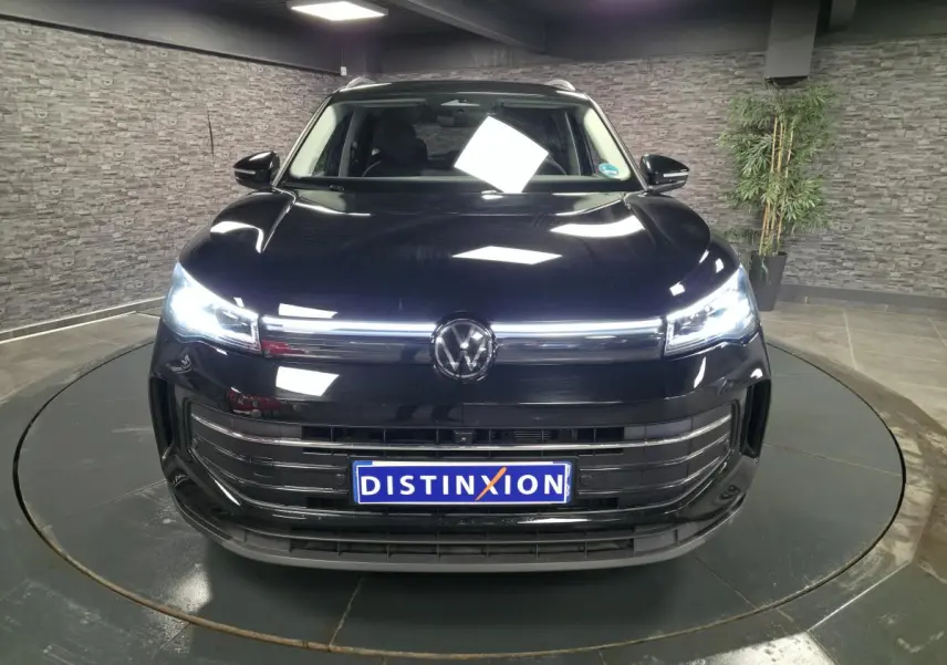 Vue avant du Volkswagen Tiguan noir 2025 avec phares LED allumés et calandre chromée distinctive.