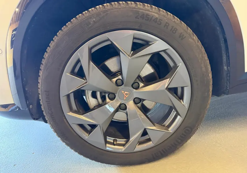 Gros plan sur la roue avant droite du CUPRA Formentor blanc, mettant en valeur la jante grise au design anguleux et le logo CUPRA central.