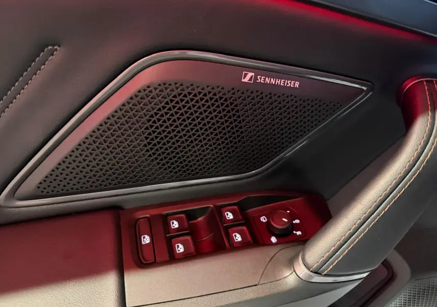 Gros plan sur la commande des vitres et haut-parleur Sennheiser côté conducteur du CUPRA Formentor blanc 2025.