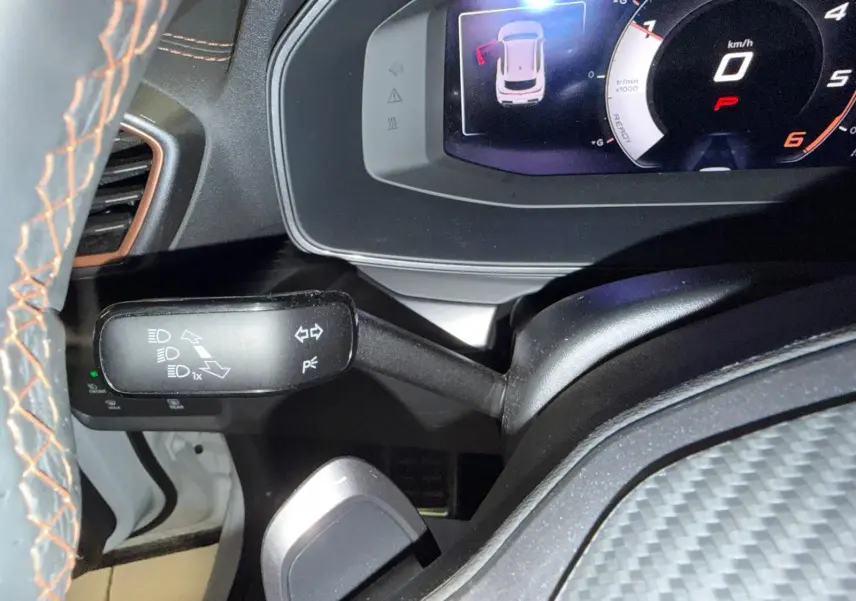 Gros plan sur le combiné d’instruments digital et la commande de clignotants dans l’habitacle du CUPRA Formentor blanc.