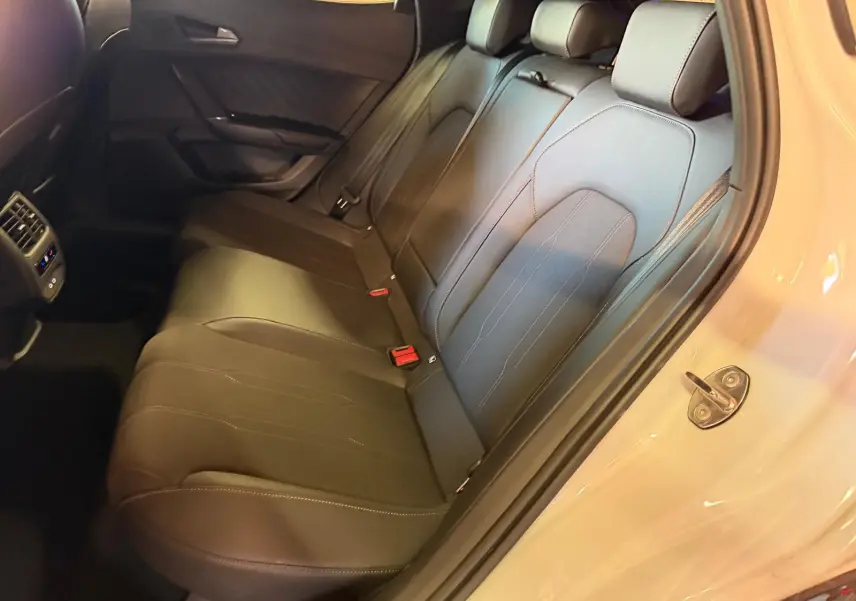 Vue intérieure côté droit sur la banquette arrière en cuir noir du CUPRA Formentor blanc 2025 avec portière ouverte.