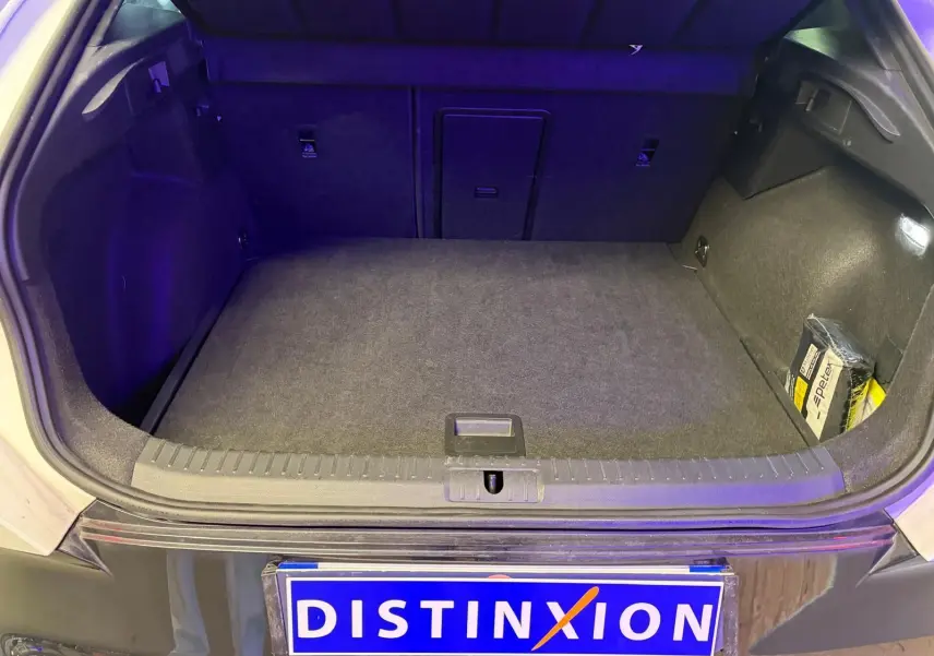 Coffre ouvert vu de l'arrière d'un CUPRA Formentor blanc 2025, avec espace de chargement propre et tapis gris.