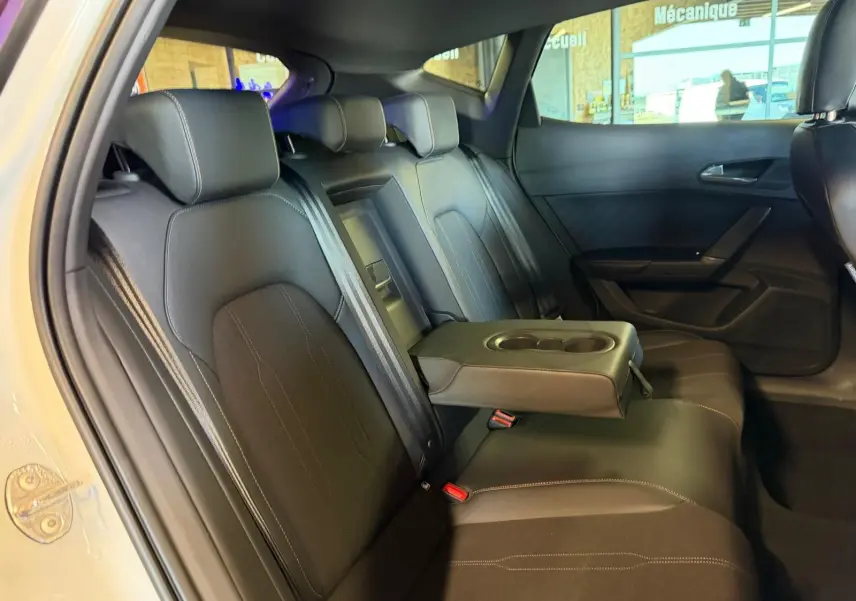 Vue intérieure côté gauche des sièges arrière noirs avec accoudoir central relevé du CUPRA Formentor blanc 2025.