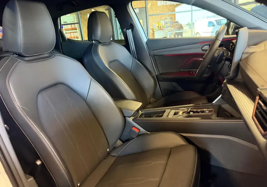 Vue intérieure côté droit du CUPRA Formentor 2025, sièges en cuir noir avec surpiqûres contrastantes et éclairage d'ambiance rouge.