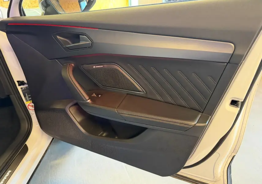 Vue rapprochée de la porte avant gauche blanche du CUPRA Formentor 2025 avec garniture noire et surpiqûres contrastées.