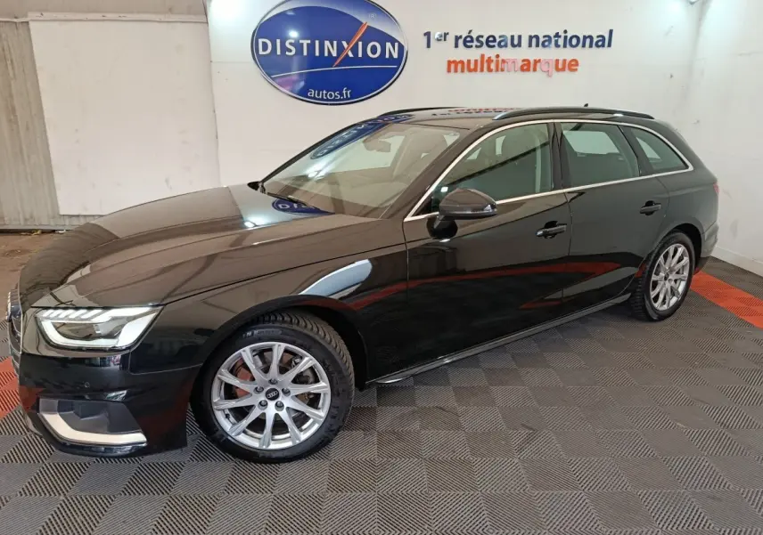 Audi A4 35 TFSI Business Line noire vue de profil droit en stationnement intérieur sur sol damier.