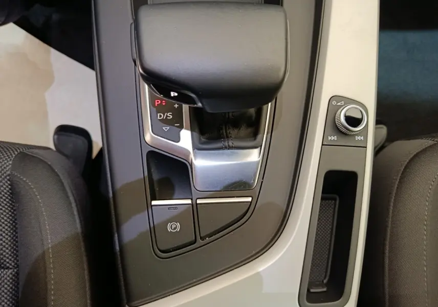 Vue rapprochée de la console centrale noire et grise de l’Audi A4 35 TFSI, avec levier de vitesse automatique et commandes.