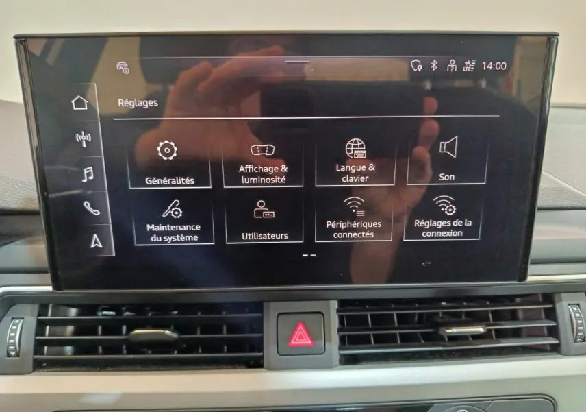 Écran tactile central de l’Audi A4 35 TFSI 2024 affichant le menu réglages, avec tableau de bord gris visible.