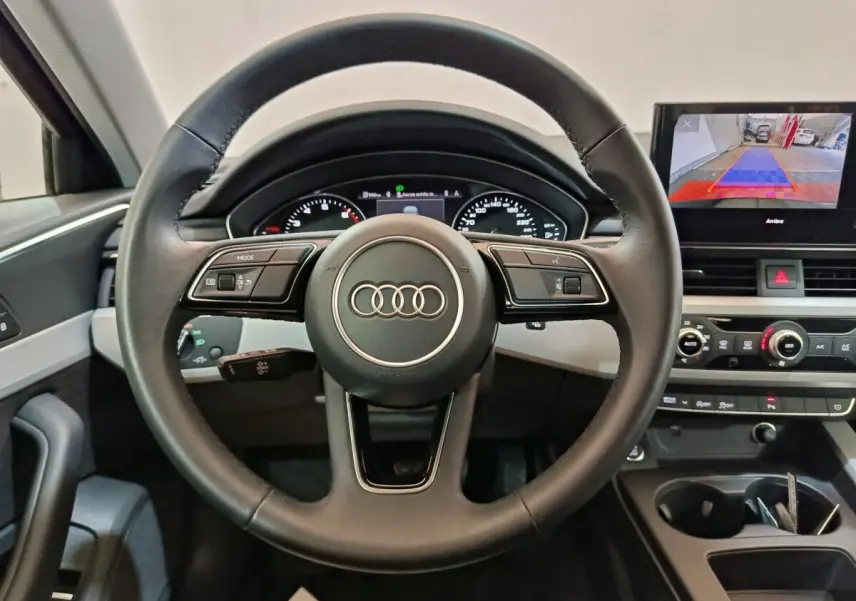 Vue intérieure frontale du volant cuir noir Audi A4 35 TFSI avec tableau de bord digital et écran central tactile.