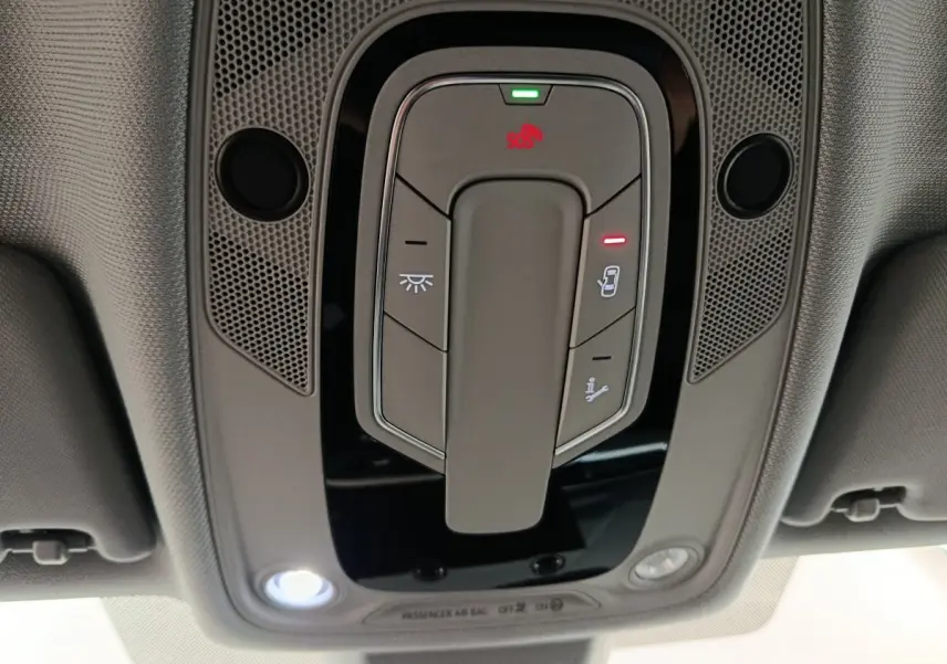 Vue en gros plan du panneau de commandes au plafond de l'Audi A4 35 TFSI Business Line noire, avec éclairage et bouton SOS.