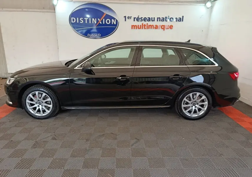 Profil droit d'une Audi A4 35 TFSI Business Line noire, break essence hybride, roues alliage et toit ouvrant visible.