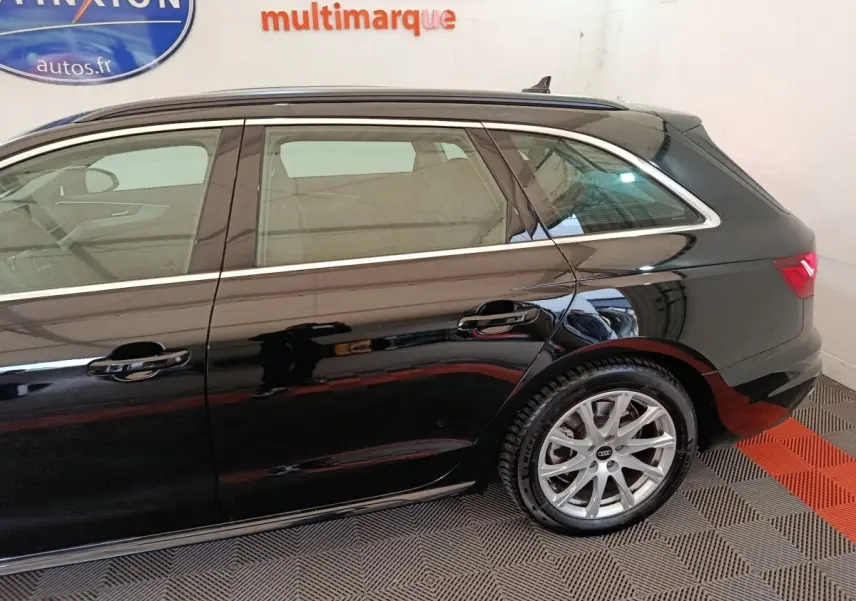 Vue latérale droite d'une Audi A4 noire 2024 avec jantes alliage et lignes chromées autour des fenêtres.
